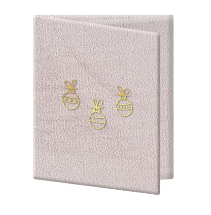 Detajl zlatih prazničnih motivov na žametni naslovnici foto albuma Trojni spomin